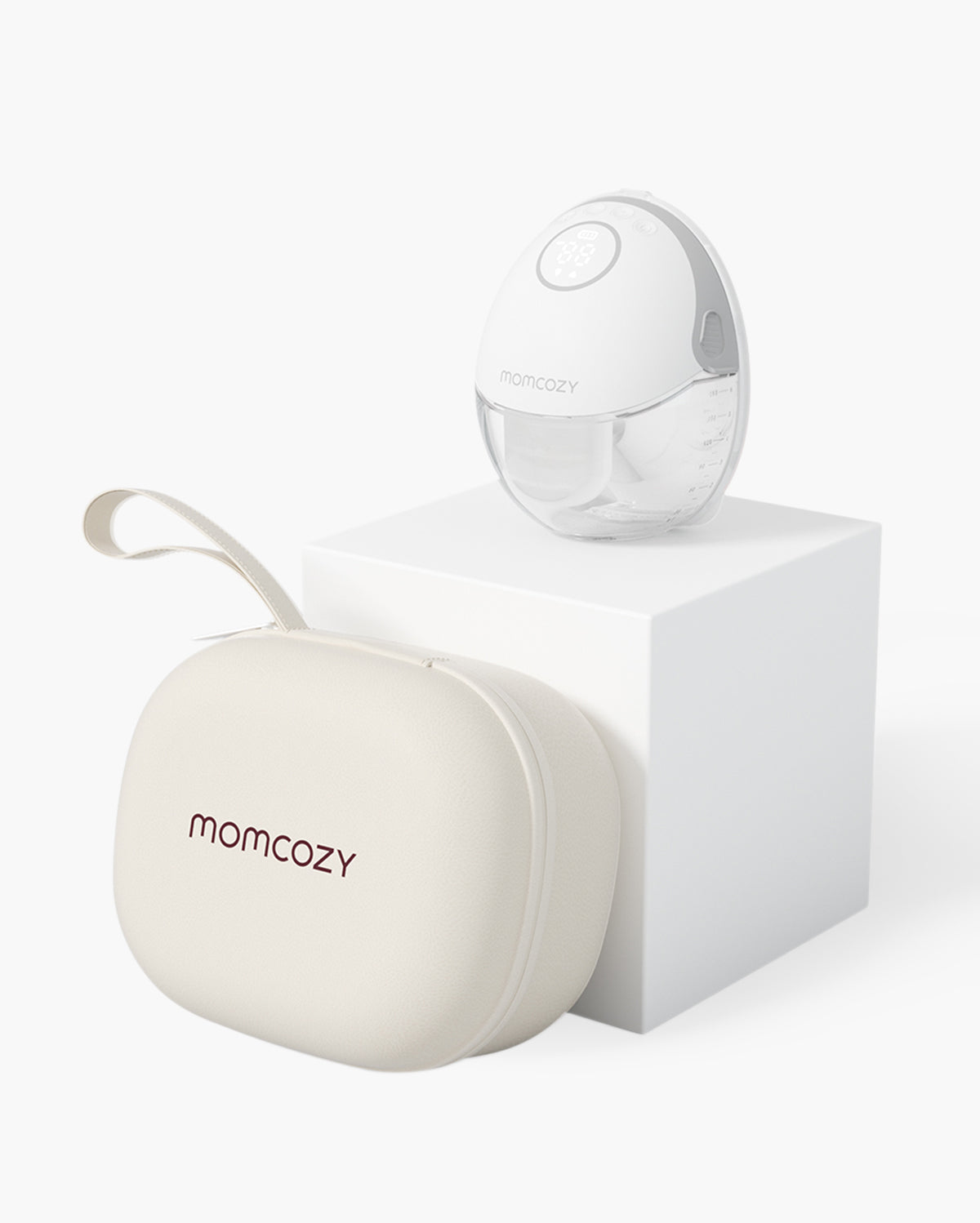 Momcozy M6 breast pump with stylish carrying case in white and beige on white pedestal.