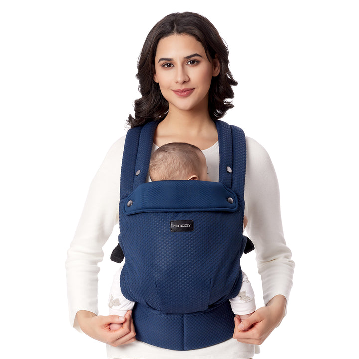 Momcozy navy baby carrier holding an infant, promoting comfort and hands-free convenience.