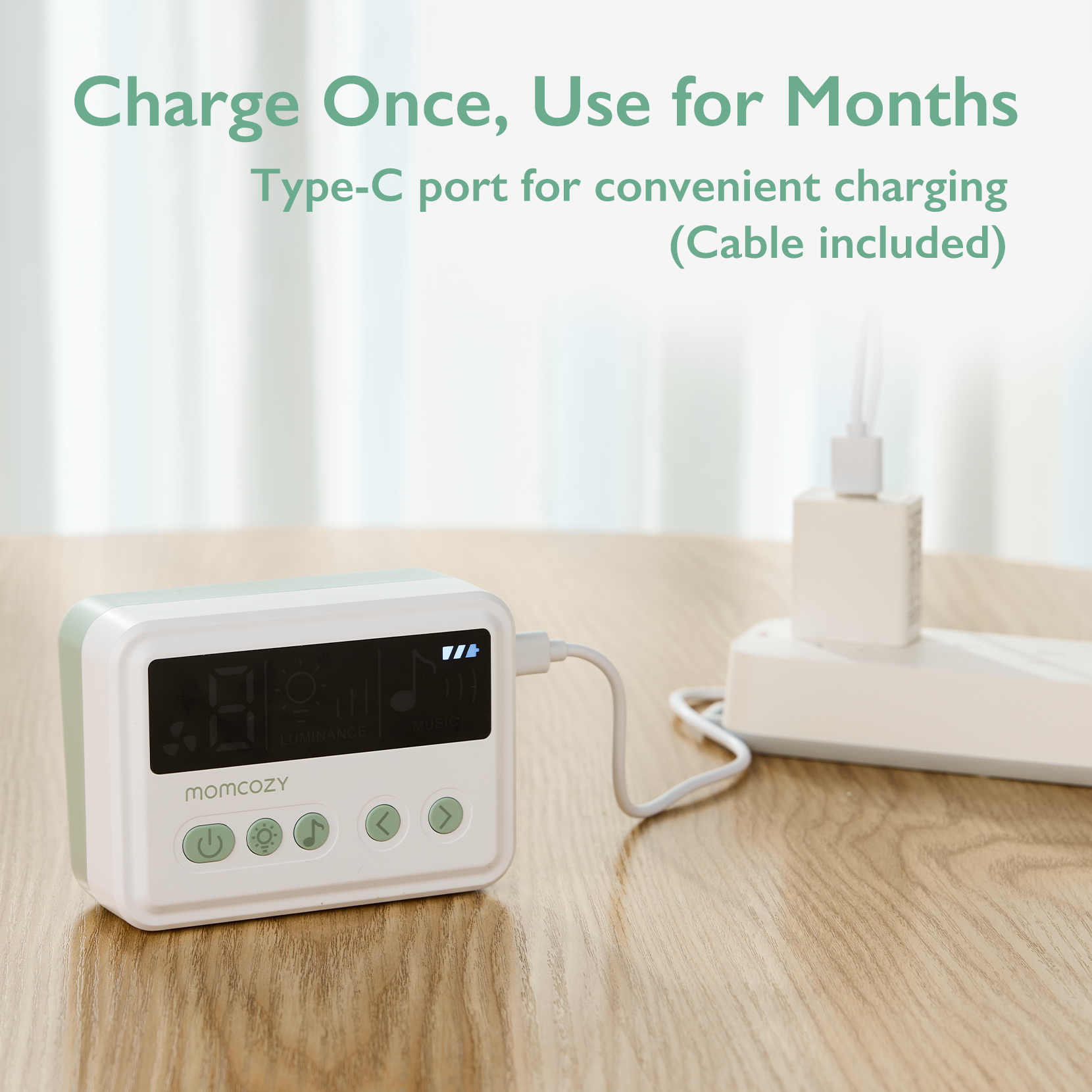 Momcozy wearable device with digital display and convenient charging for months. White and green design with control buttons.