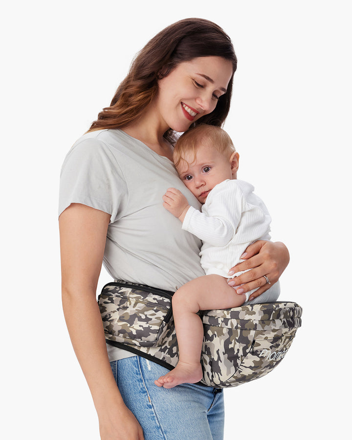 Mother comfortably holding baby in camo-patterned 3D Belly Protector & EVA Massage Board-Baby Hip Seat Carrier by Momcozy