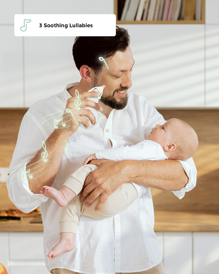 Dad using Momcozy Baby Nasal Aspirator on baby with soothing lullabies in bright kitchen.