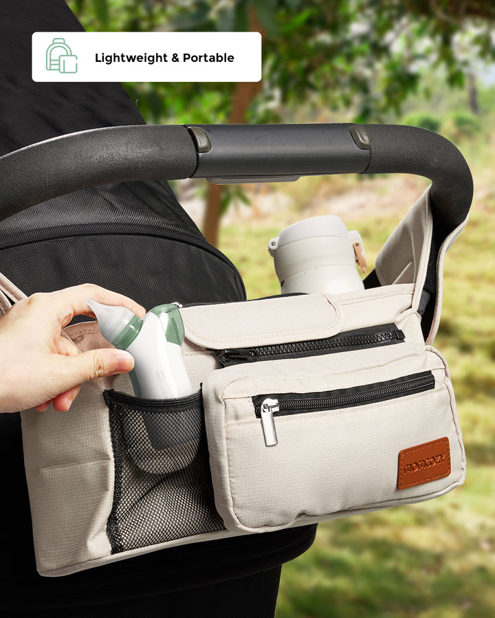 Lightweight and portable Momcozy Baby 2-in-1 Nasal Aspirator, easily carried in a bag for daily outings.