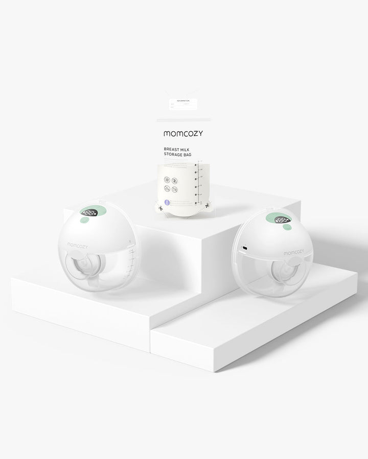 Momcozy M5 All-in-one Wearable Breast Pump displayed with breast milk storage bags on a white platform